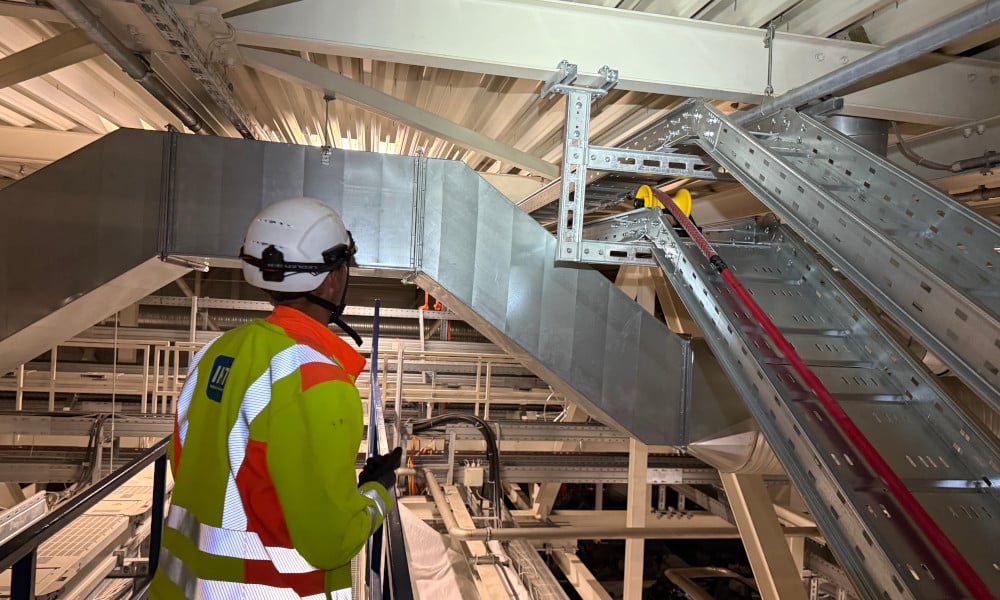 IKT-Höhenarbeiter bei Supervision der Kabeltrassen-Montage im BMW-Werk Leipzig — DIN-ISO-konforme Befestigung über laufender Produktion